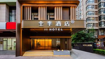 A hotel entrance with a modern design, featuring a prominent sign and a set of stairs leading up to the door.
