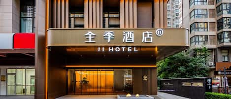 A hotel entrance with a modern design, featuring a prominent sign and a set of stairs leading up to the door.