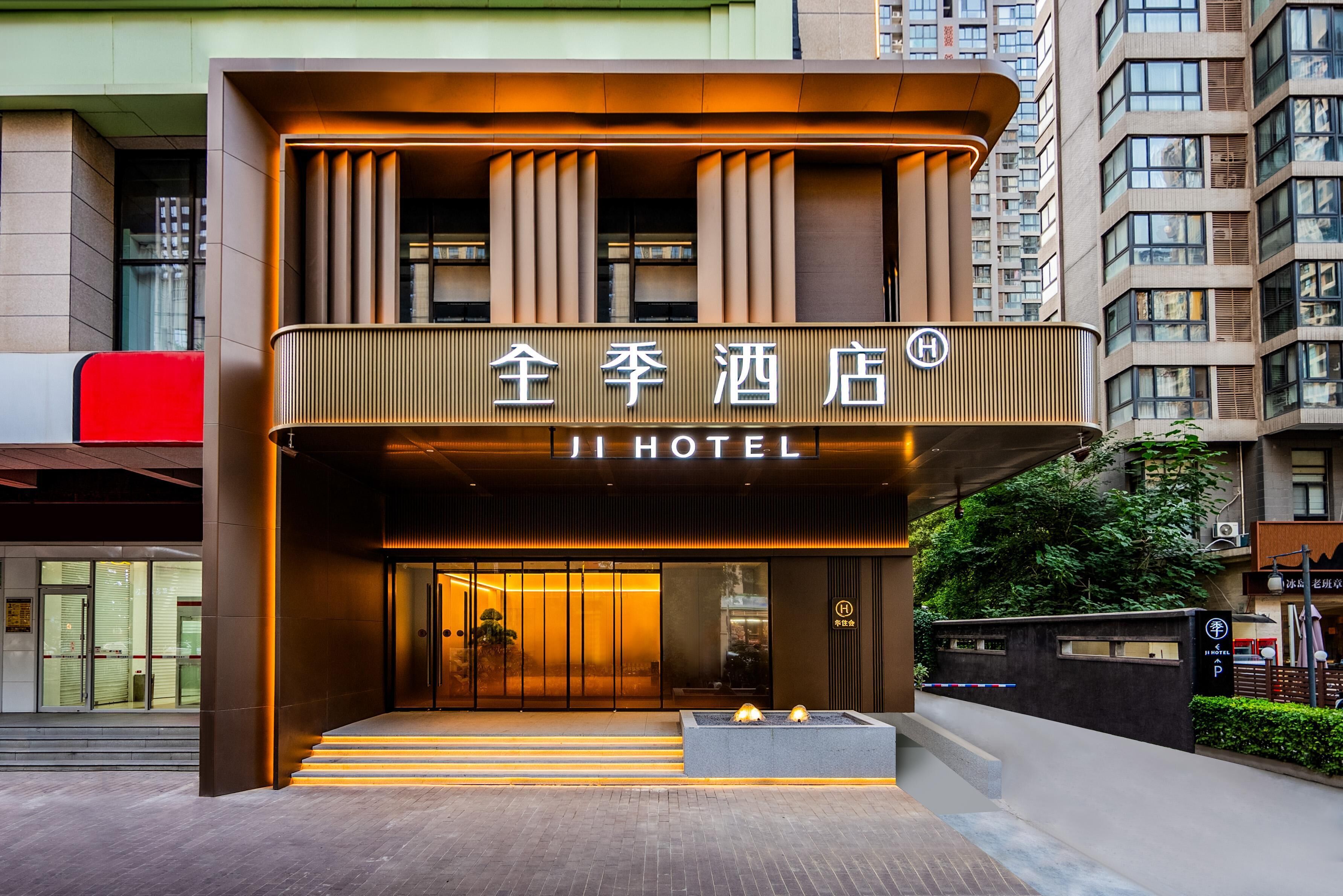 A hotel entrance with a modern design, featuring a prominent sign and a set of stairs leading up to the door.
