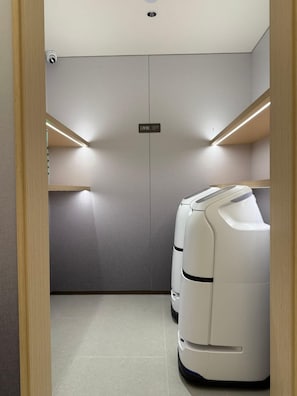 A room with a massage chair, a sign indicating a storage area, and a ceiling-mounted security camera. - JI Hotel (Xi'an)