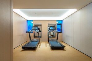 A room with two treadmills, a mirrored wall, and a cityscape view. - JI Hotel (Xi'an)