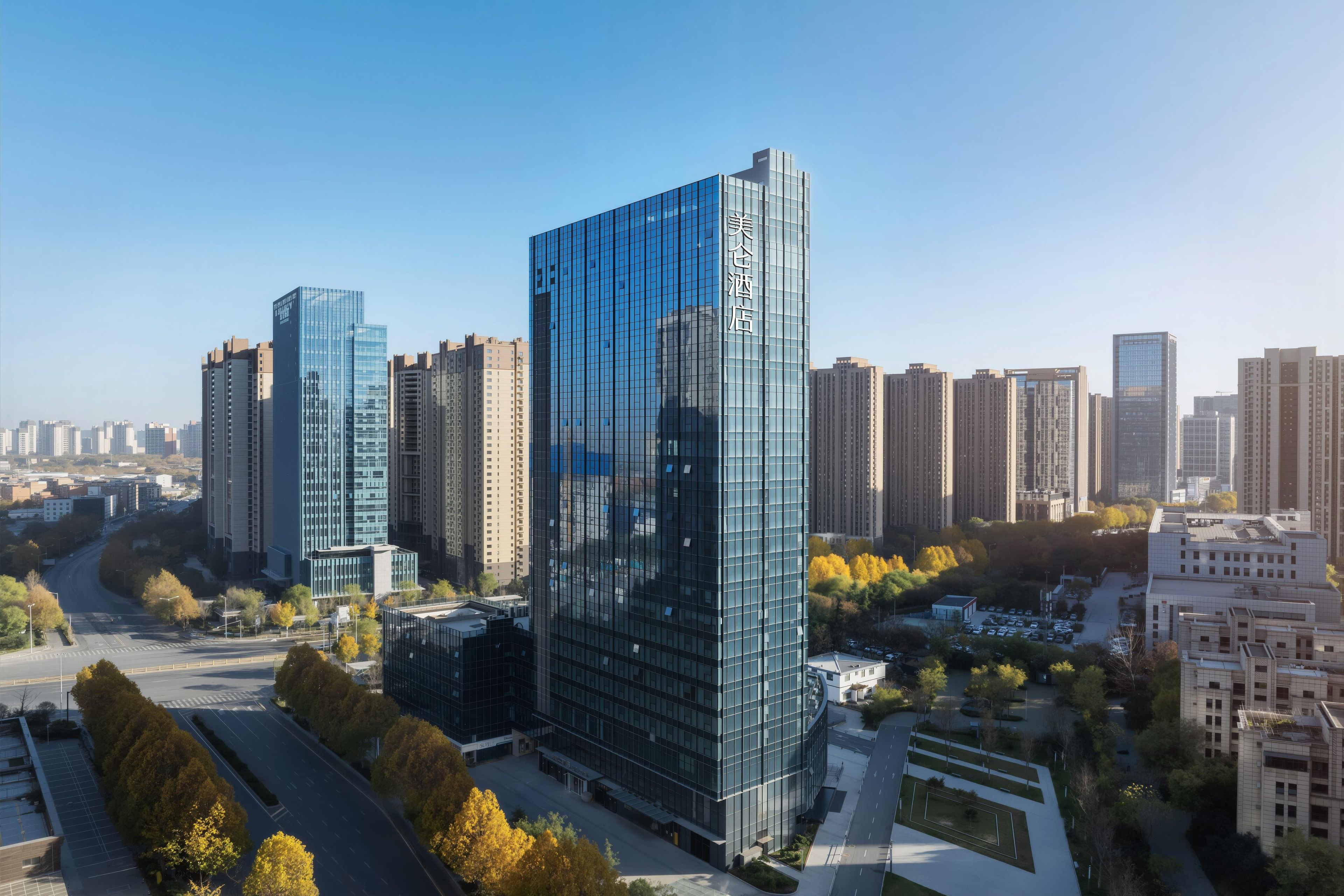A modern high-rise building with a glass facade, surrounded by other high-rise buildings and a clear sky.
