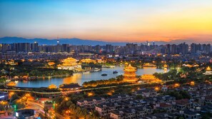 A cityscape with traditional architecture, modern buildings, and a body of water. - Meilun Hotel (Xi'an)