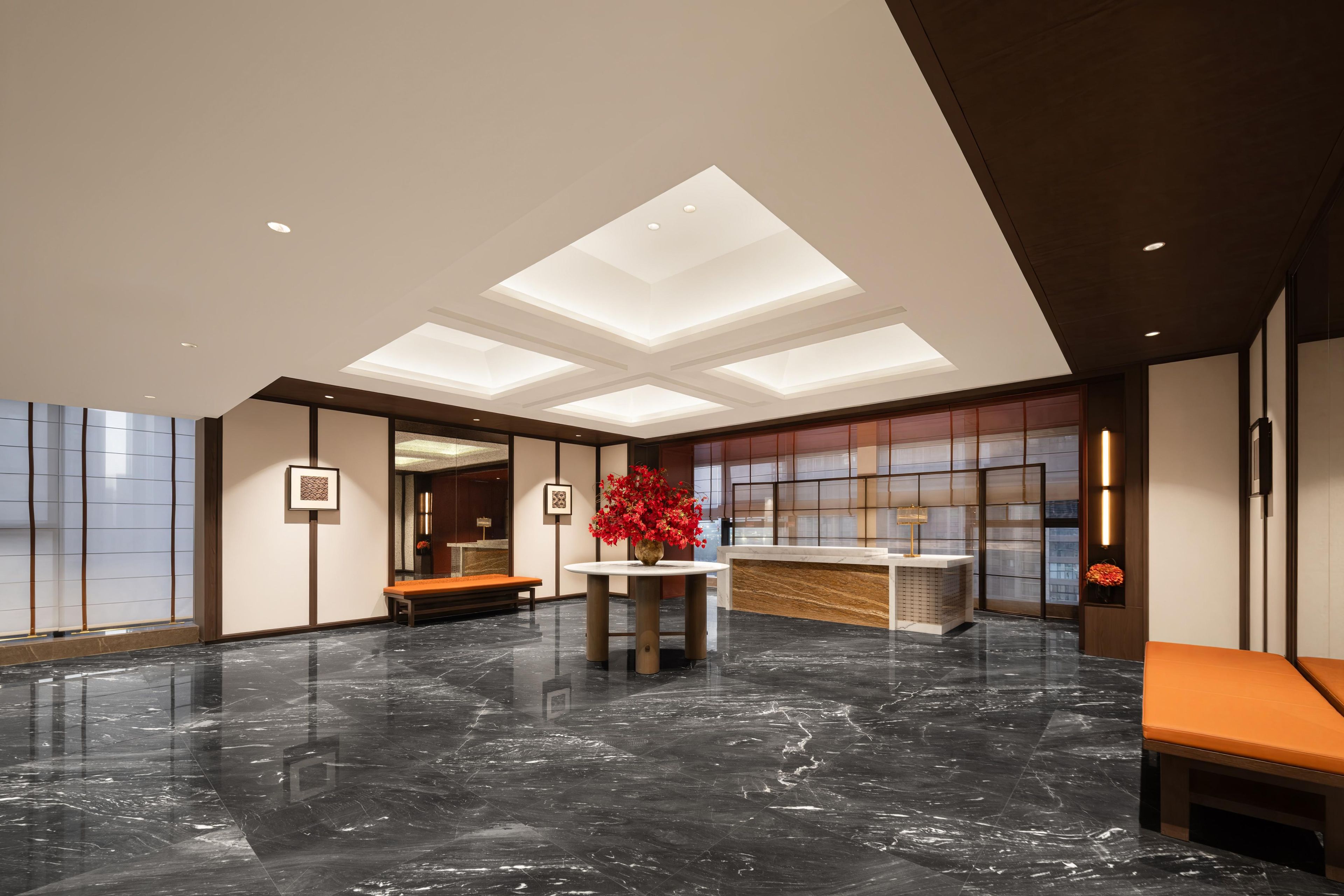 A lobby with a marble floor, a reception desk, and a seating area.