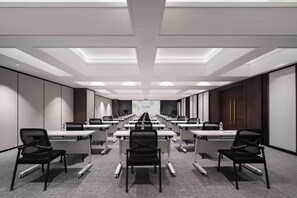 A conference room with rows of tables and chairs, a projector screen, and a modern ceiling design. - Meilun Hotel (Xi'an)