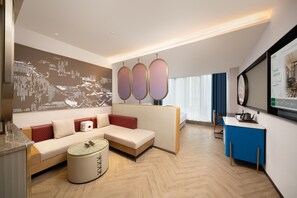 A modern hotel room with a sofa, a small round table, a decorative wall piece, and a television. - Meilun Hotel (Xi'an)