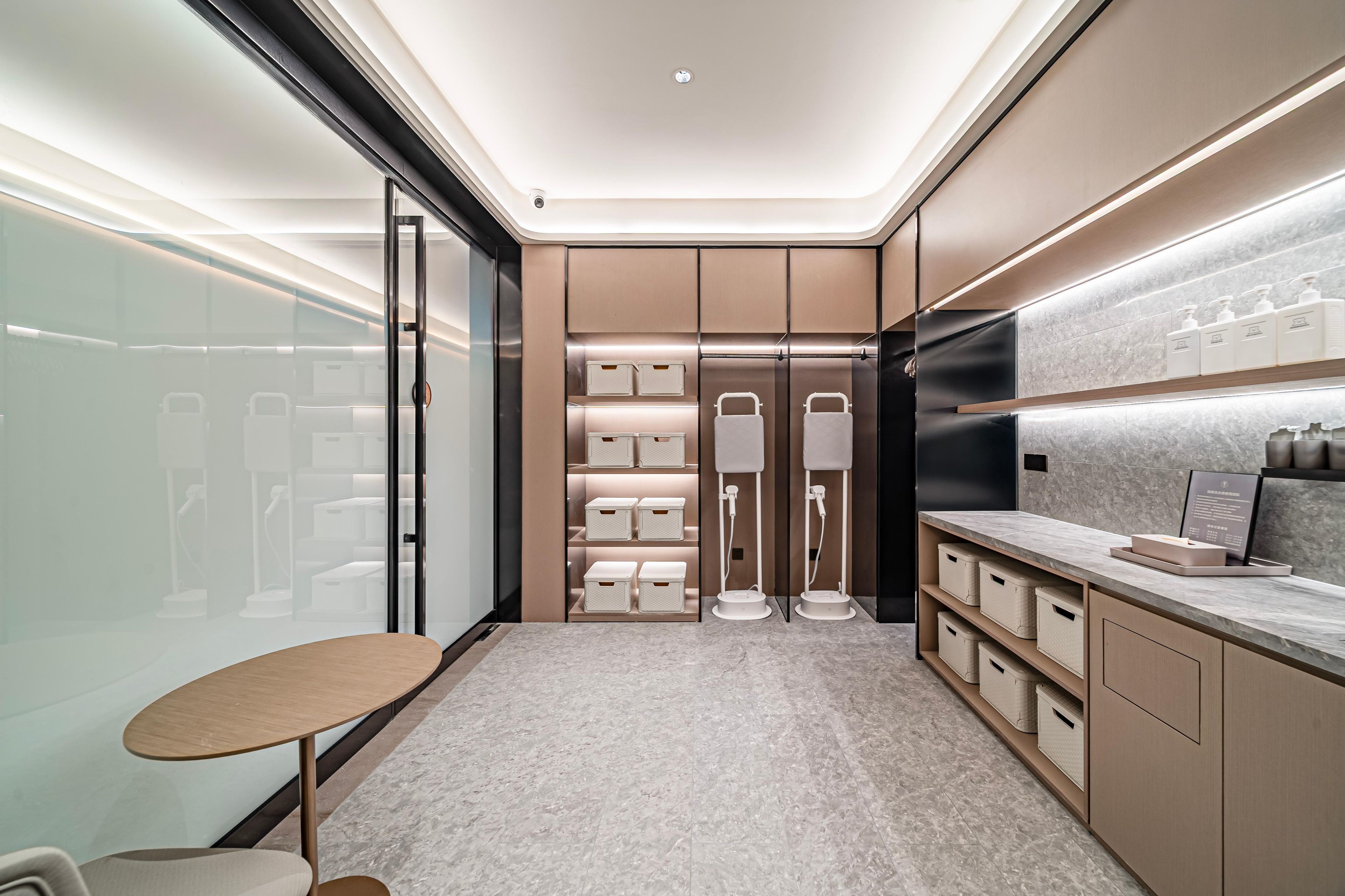 A modern bathroom with a vanity, towel racks, and storage cabinets.