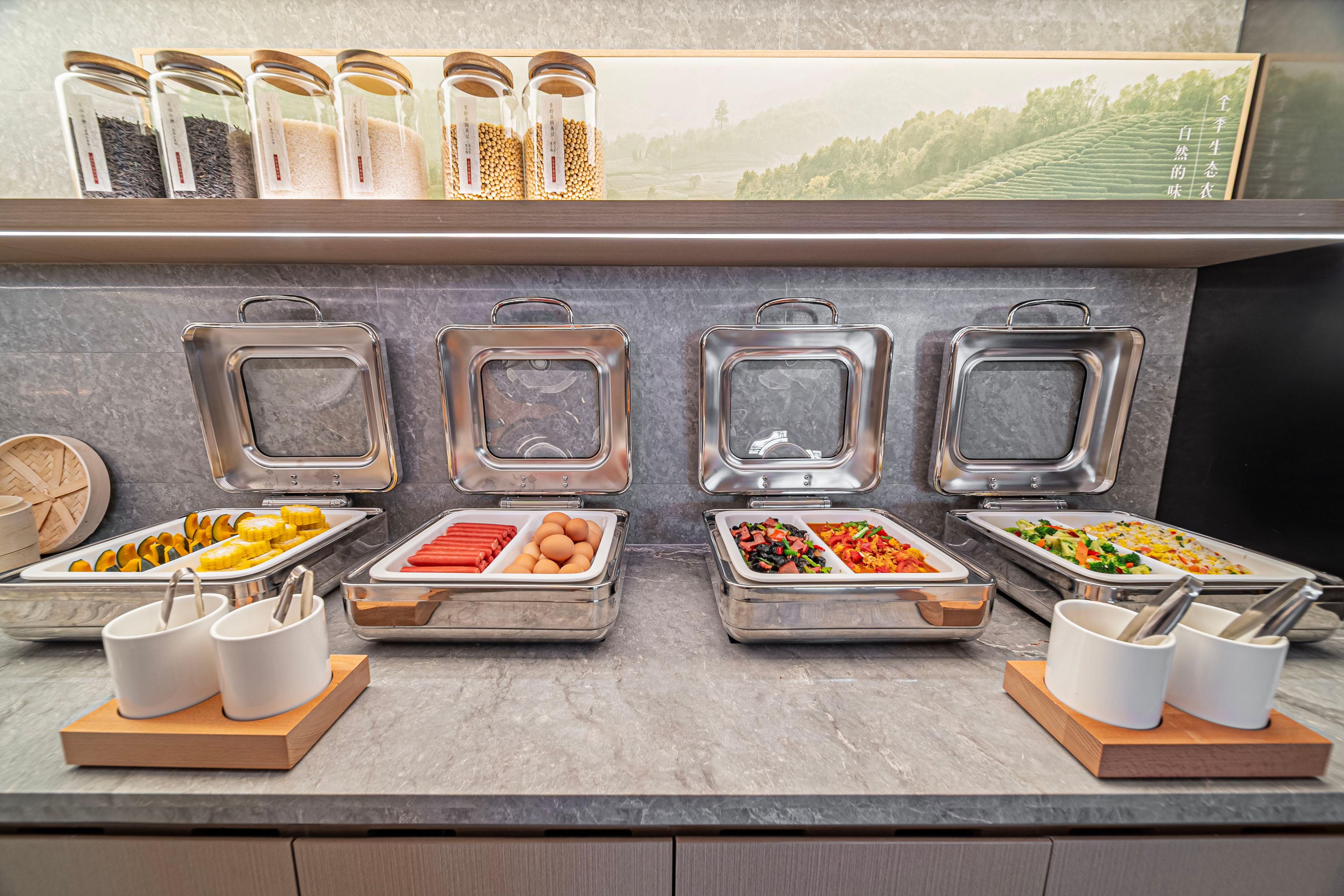 A buffet setup with various food items and condiments.