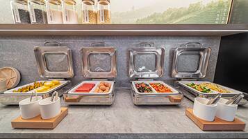 A buffet setup with various food items and condiments.