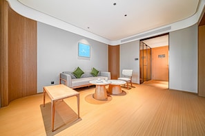 A modern interior with a sofa, two chairs, a coffee table, and a small table. - JI Hotel (Xi'an)