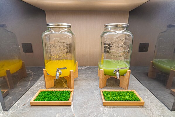 Two glass dispensers with wooden bases and green grass mats, labeled 'Yorkshire' and 'Estonia,' on a marble countertop. - JI Hotel (Xi'an)