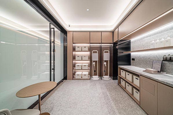 A modern bathroom with a vanity, towel racks, and storage cabinets. - JI Hotel (Xi'an)
