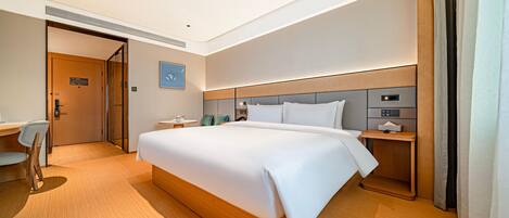 Ein Hotelzimmer mit einem großen Bett, einem Schreibtisch und einem Stuhl.