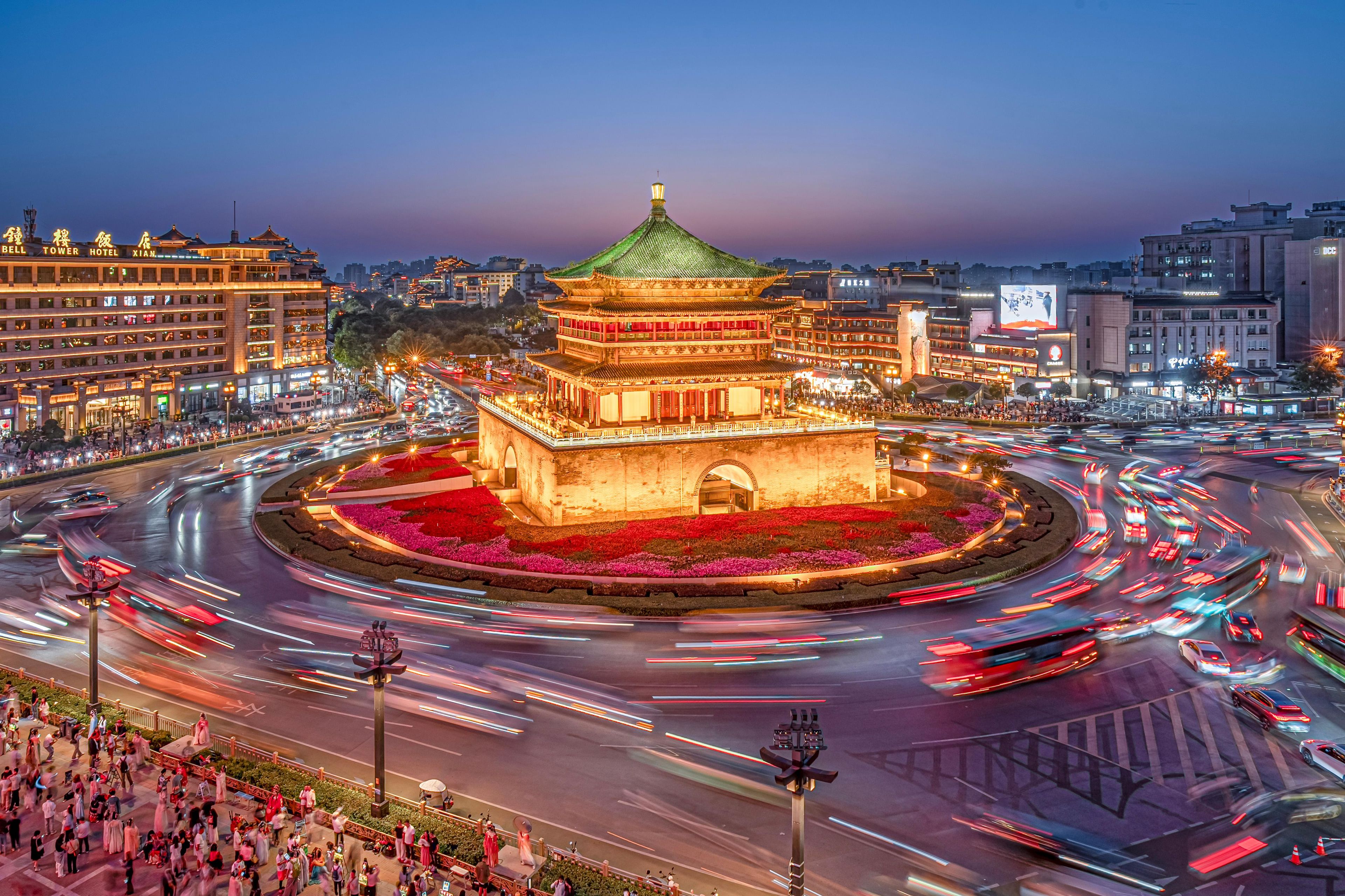 Een traditioneel Chinees gebouw met een groen dak, omringd door een rondverkeerspatroon.