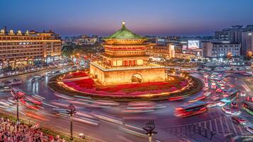 Een traditioneel Chinees gebouw met een groen dak, omringd door een rondverkeerspatroon.