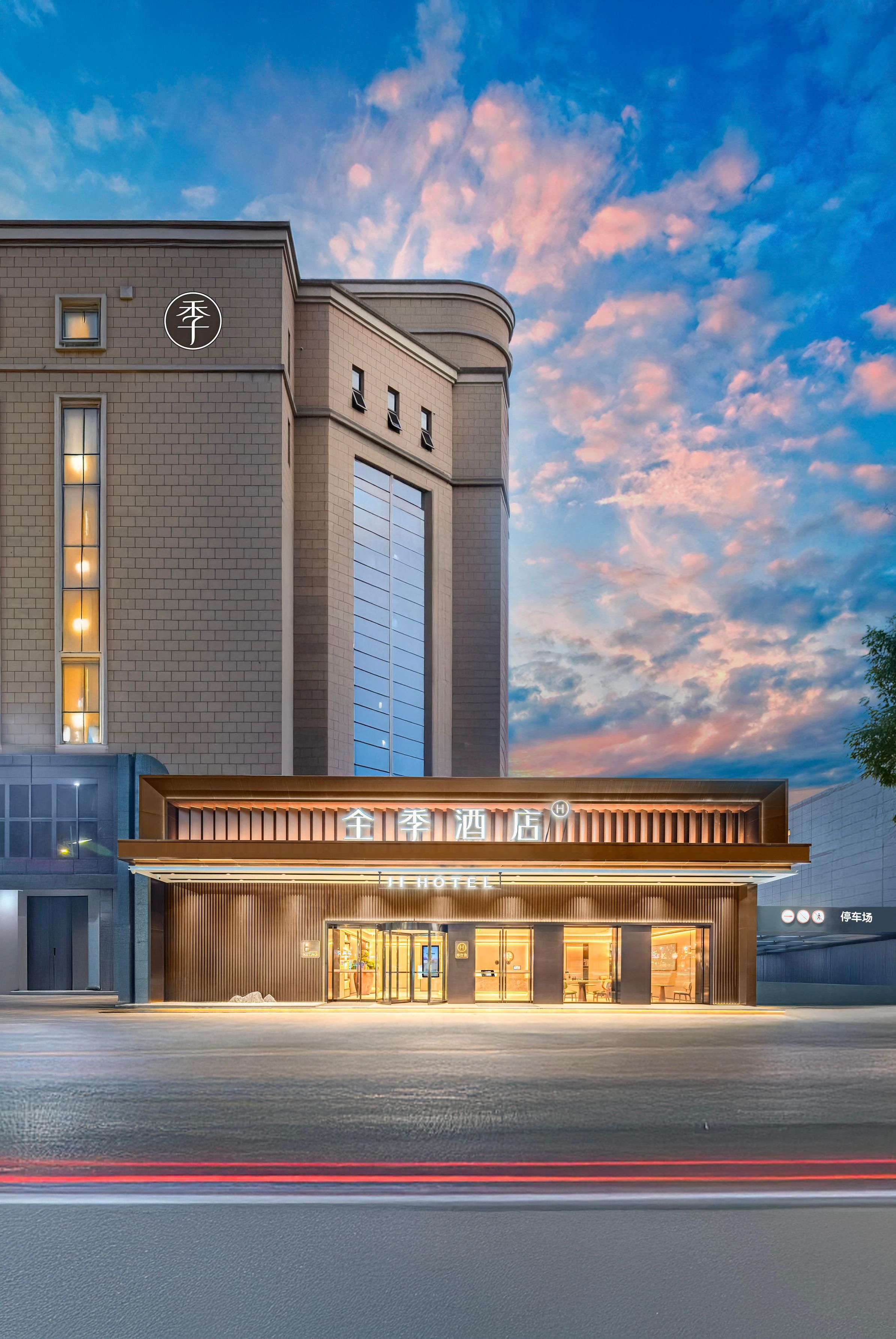 Ein Hotel mit moderner Fassade, großen Fenstern und einem markanten Eingang.