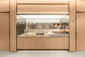 A compact kitchen with a built-in stove, a microwave, and a small sink. - JI Hotel (Xi'an)