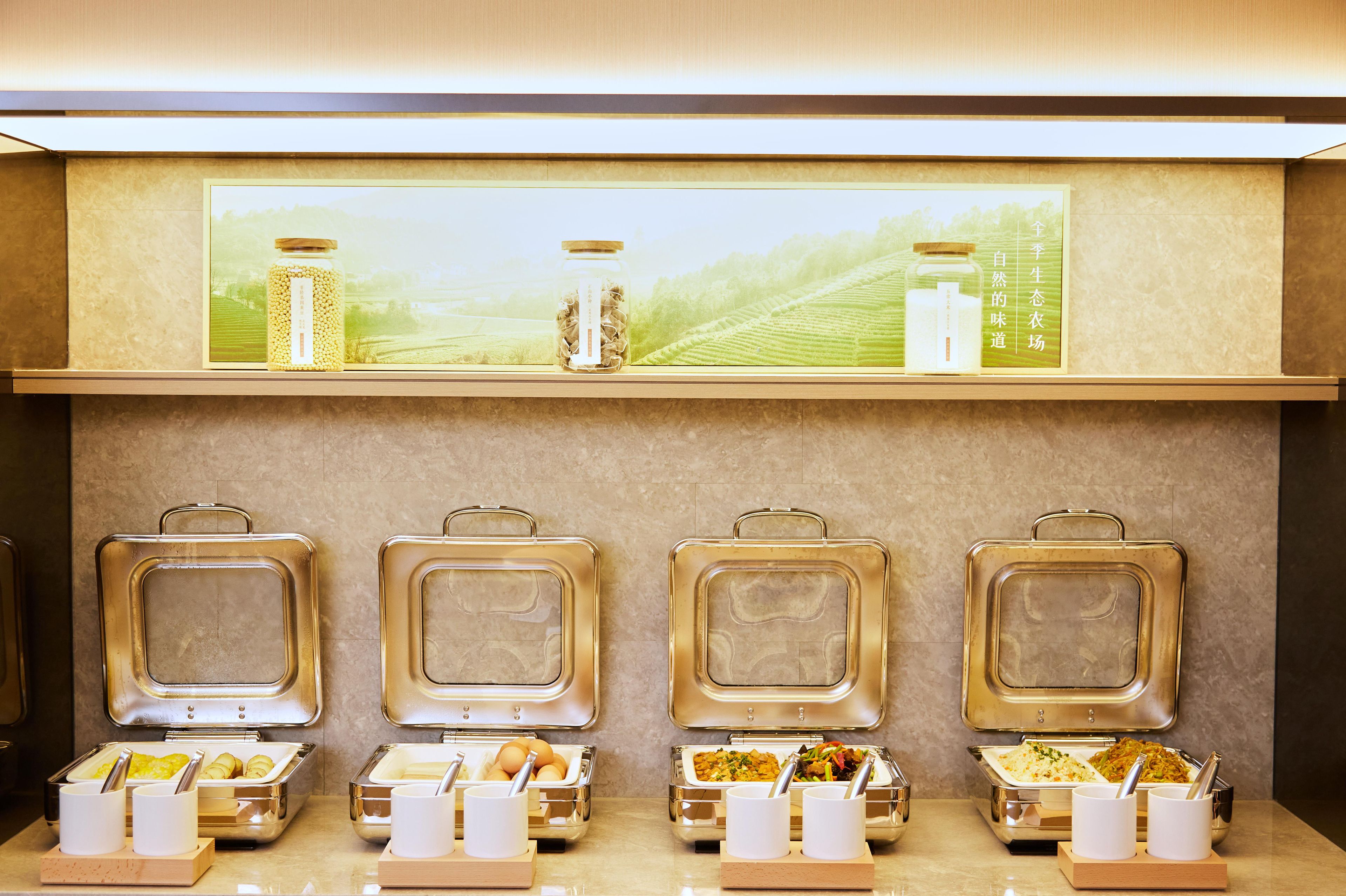 Uma mesa de buffet com vários recipientes de comida e utensílios.
