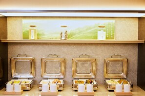 Uma mesa de buffet com vários recipientes de comida e utensílios.