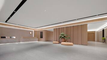 A modern reception area with a reception desk, a large potted plant, and a minimalist design.