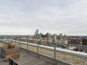 Eine Dachterrasse mit Blick auf einen Stadtpanoramablick, einschließlich Wolkenkratzer und einem fernen Horizont.