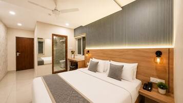 A modern bedroom with a large bed, bedside tables, a mirror, and a ceiling fan.