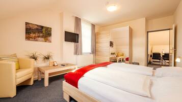Ein Hotelzimmer mit Bett, Schreibtisch, Stuhl, Fernseher und einem Gemälde an der Wand.