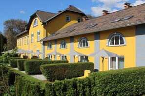 En gul bygning med mange vinduer og et skråt tag.