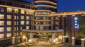 A multi-story hotel with a central courtyard, large windows, and a prominent entrance.