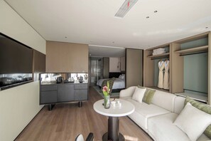 A modern hotel room with a kitchenette, a sofa, a small round table, and a walk-in closet. - Quanzhou West Street Huajianfu · Liuxi (Quanzhou)