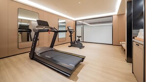 A modern home gym with a treadmill, stationary bike, and exercise equipment.