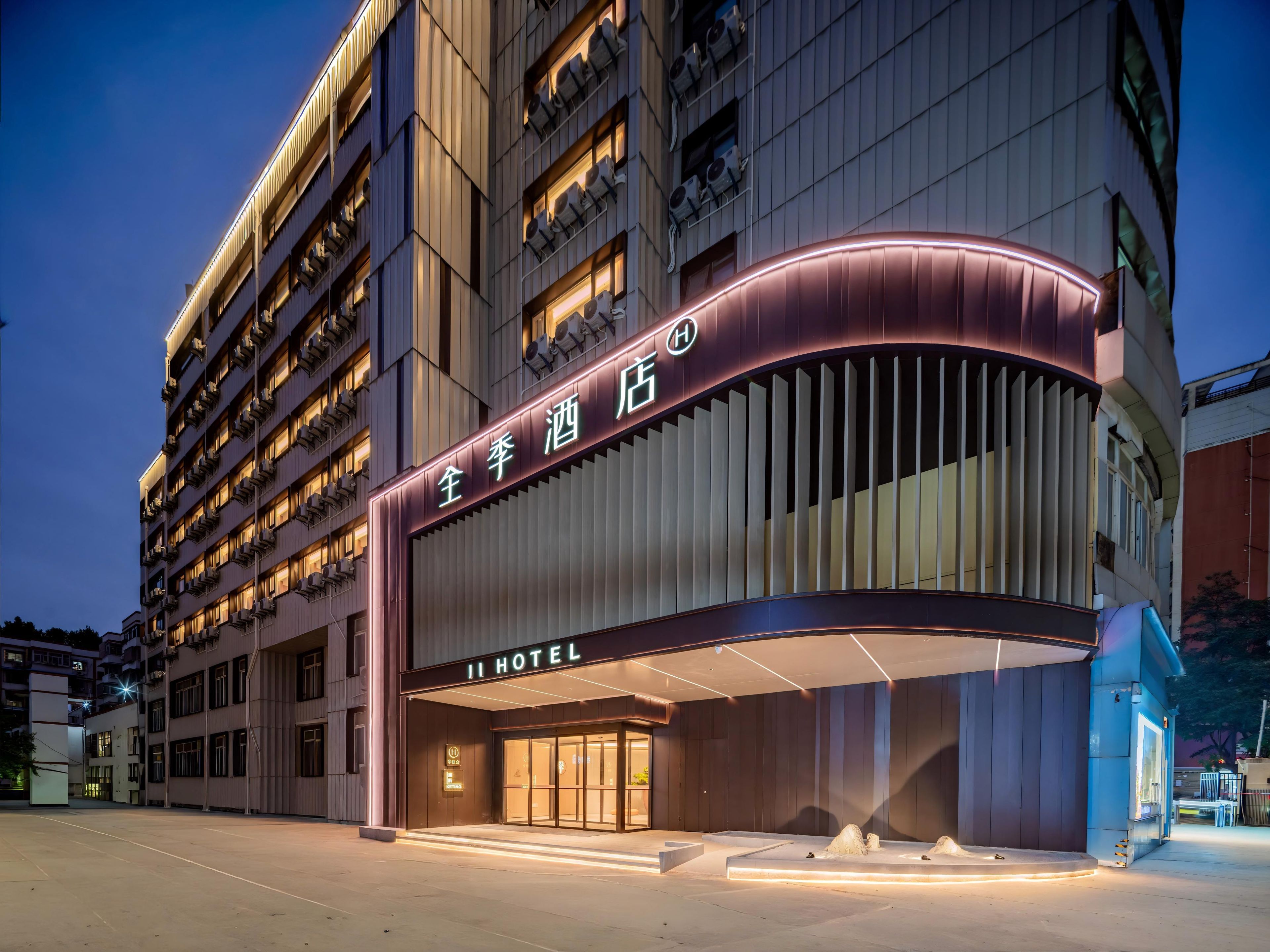A hotel with a modern facade, multiple floors, and illuminated signage.