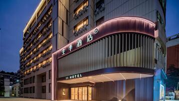 A hotel with a modern facade, multiple floors, and illuminated signage.