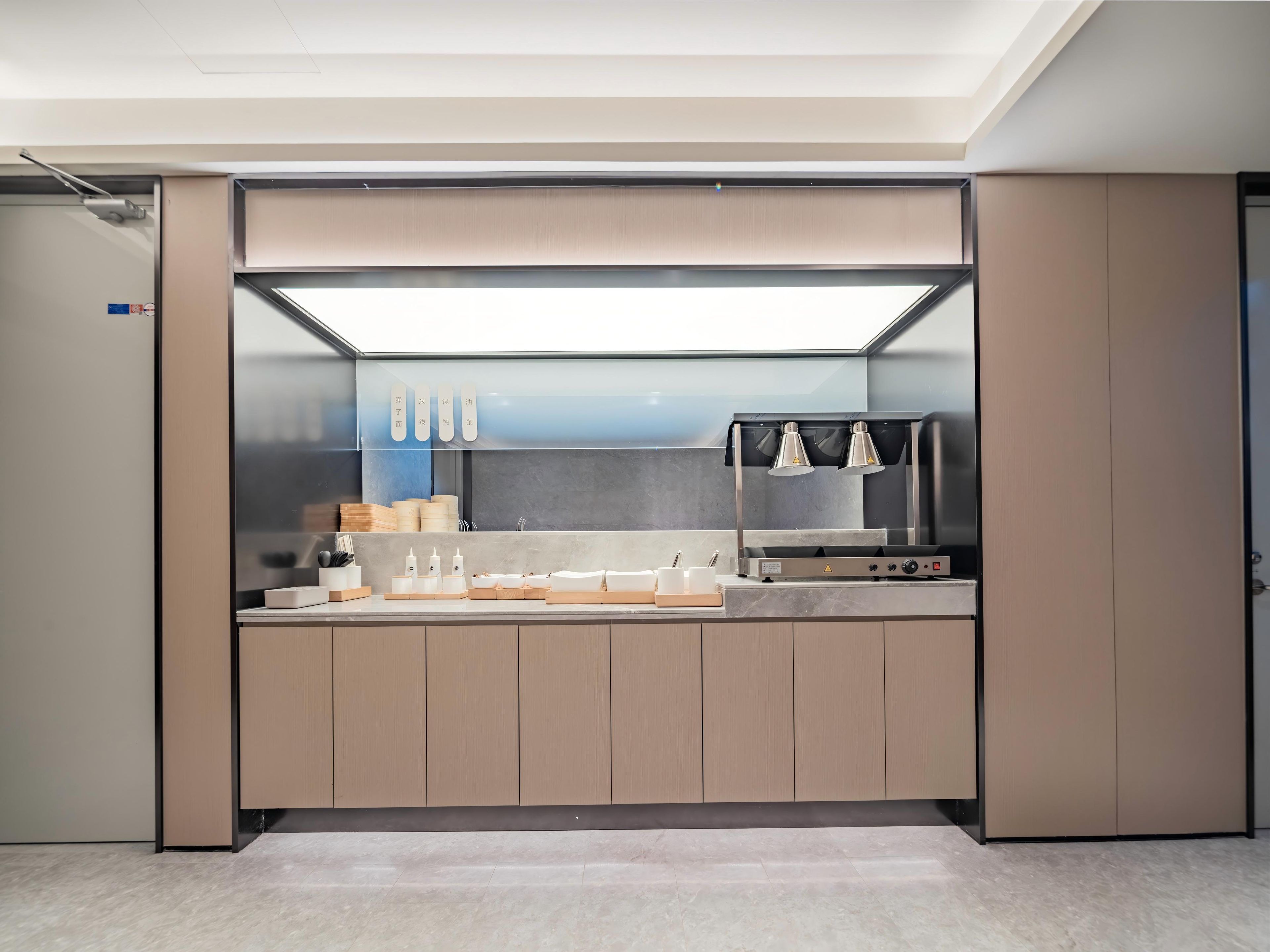 A modern kitchen with a built-in stove, a microwave, and a coffee machine.