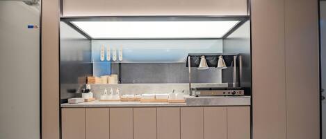 A modern kitchen with a built-in stove, a microwave, and a coffee machine.