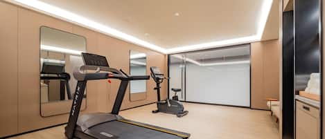 A modern home gym with a treadmill, stationary bike, and exercise equipment.