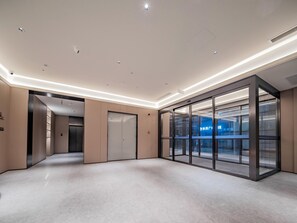 A modern interior with a glass partition, recessed lighting, and a clean, minimalist design. - JI Hotel Xian Jiaotong University Xingqing Campu (Xi'an)