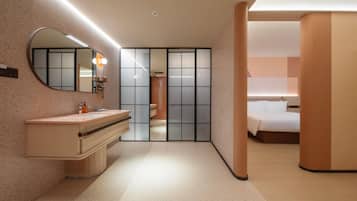 A modern hotel room with a vanity, mirror, and a bed.
