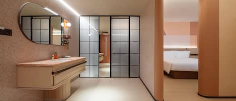 Una habitación de hotel moderna con tocador, espejo y cama.