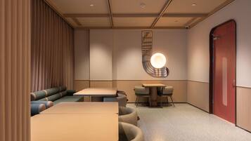 A modern interior with seating arrangements, a staircase, and a door.