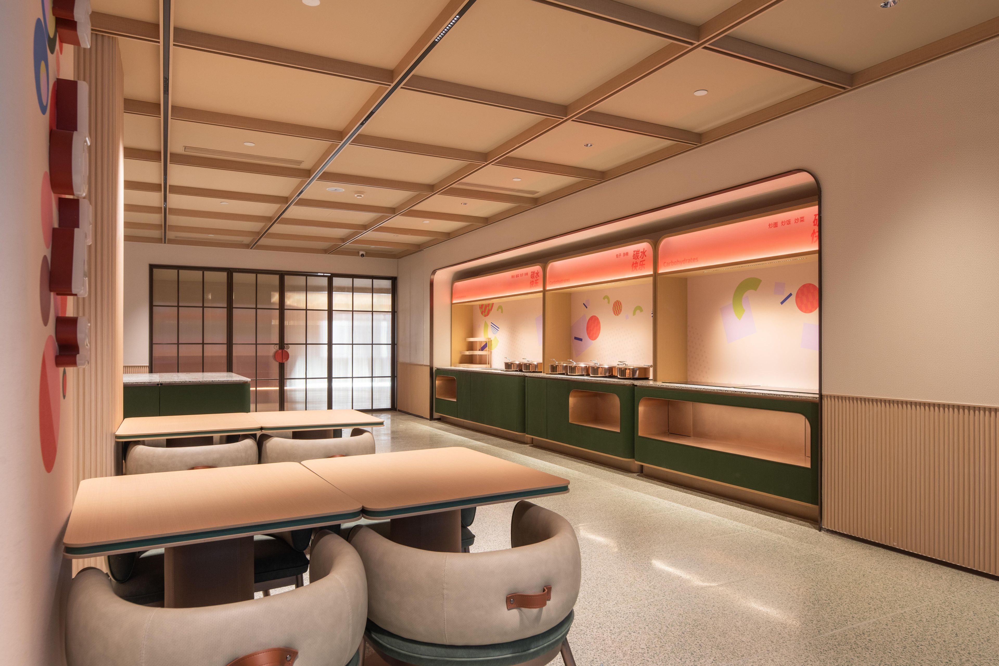 Een modern interieur met een lange toonbank, een zithoek en uitzicht op buiten.
