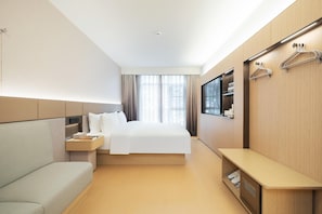 A modern hotel room with a bed, a sofa, a bedside table, a TV, and a wardrobe with a mirror. - JI Hotel (xian Jiaotong University Qinglong Templ (Xi'an)