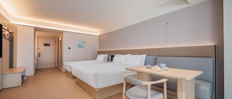 Une chambre d’hôtel avec un lit, un bureau et une chaise. Une porte donne accès à une autre pièce.