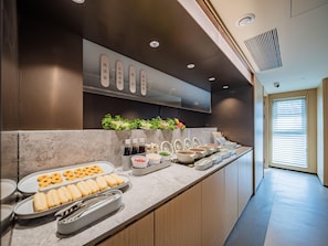 A buffet setup with various food items and condiments. - JI Hotel (xian Jiaotong University Qinglong Templ (Xi'an)