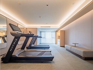 A modern hotel gym with treadmills, a seating area, and a view of the outside. - JI Hotel (xian Jiaotong University Qinglong Templ (Xi'an)