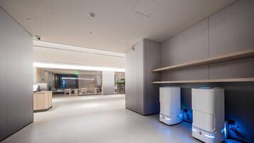 Un intérieur moderne au design épuré et minimaliste, comprenant un espace d’accueil, des sièges et deux grands appareils éclairés situés à droite.
