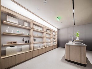 Un espacio comercial moderno y bien iluminado con estanterías de madera que exhiben diversos productos.