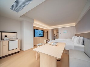 A modern hotel room with a bed, a desk, a TV, and a kitchenette. - JI Hotel (xian Jiaotong University Qinglong Templ (Xi'an)