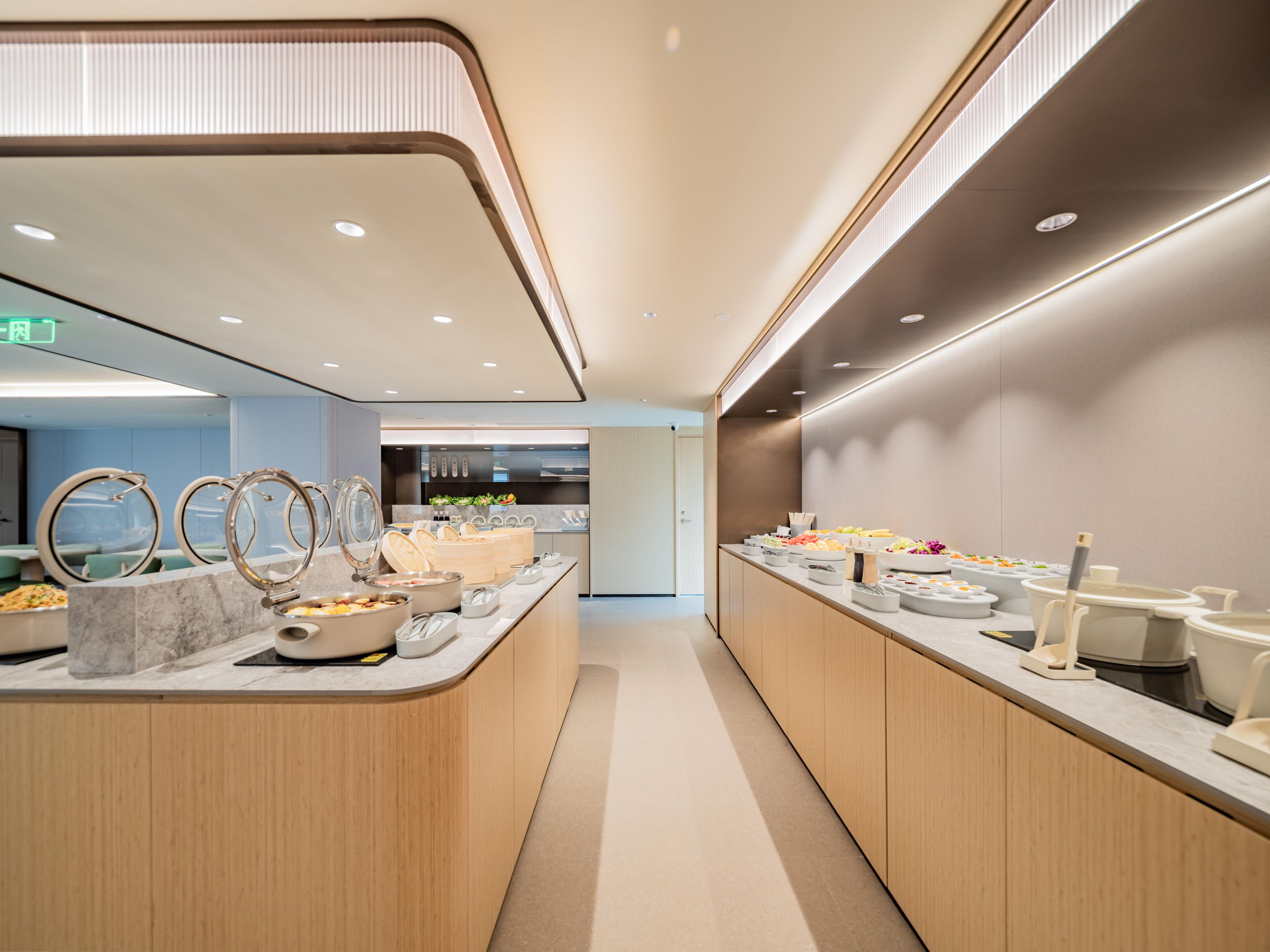 Un espace buffet moderne et bien éclairé, offrant une grande variété de plats et présentant un design épuré et contemporain.