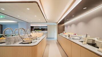 Un espace buffet moderne et bien éclairé, offrant une grande variété de plats et présentant un design épuré et contemporain.